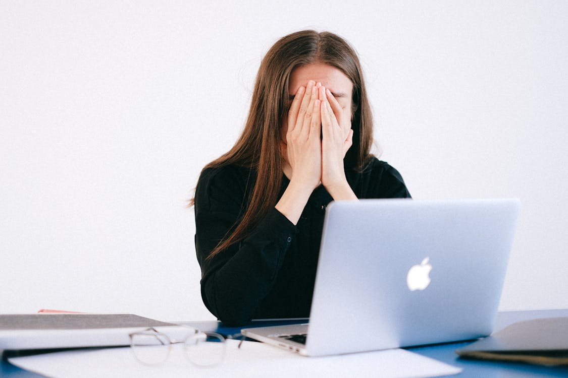 Kobieta zmęczona pracą przy laptopie